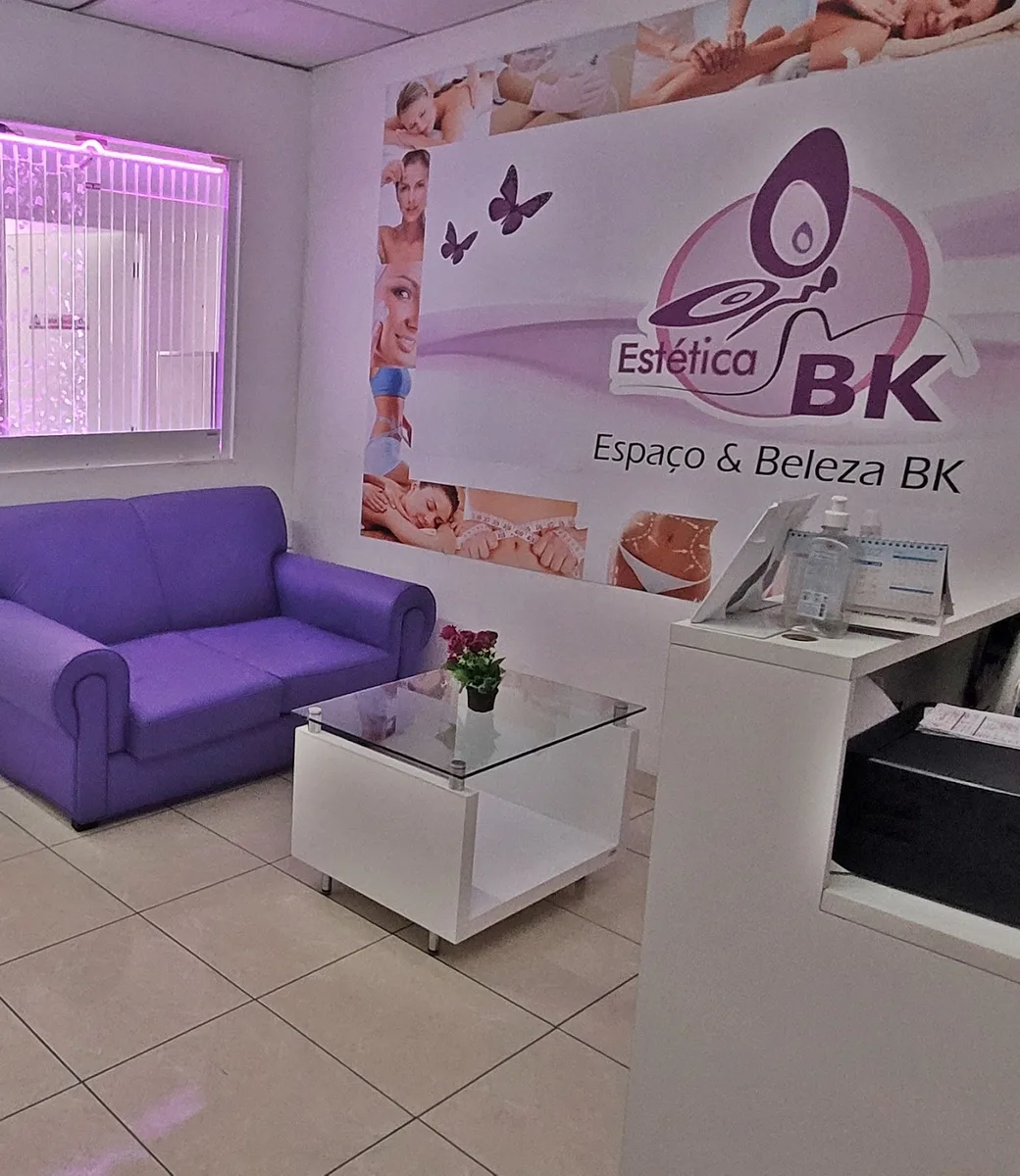 Recepção da Estética BK, com os sofás lilás e o letreiro da marca, no Jardim Jaú, São Paulo